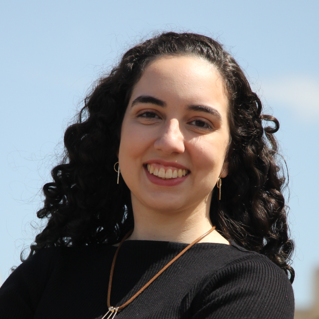 Beatriz. Mulher branca. Cabelo cacheado. Cabelo e olhos castanhos.